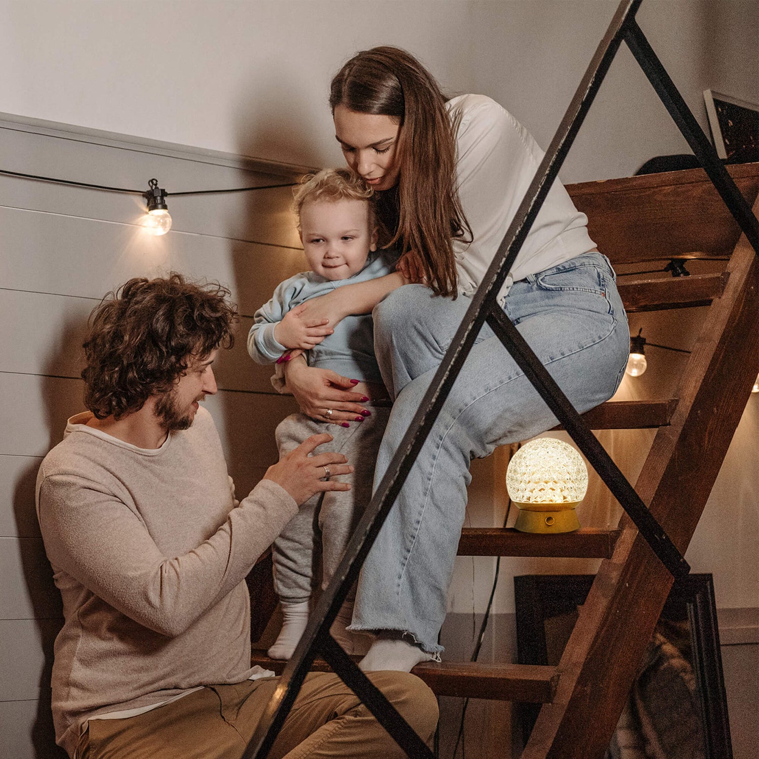 Cordless-Rechargeable-Battery-Cute-portable, family are playing on the ladder and gold lamp is lighting beside them.
